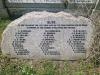 A memorial stone situated next to the mass grave with names of those killed and buried eslewhere