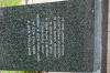 Black granite pillar with metal sculpture on top, with inscriptions on sides of each