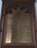 Brass plaque mounted n ornate wooden backboard/frame