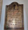 A brass plaque with decorated cross edge and Latin cross dedicated to the subject and detailing the circumstances of his death.