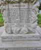 Latin cross, in Portland Stone, set on a rough hewn plinth and an inset tablet, with the dedication and WW1 names in black lettering. The whole is on four steps with the uppermost step bearing WW2 name.