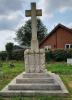 Latin cross, in Portland Stone, set on a rough hewn plinth and an inset tablet, with the dedication and WW1 names in black lettering. The whole is on four steps with the uppermost step bearing WW2 name.