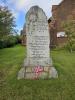 Stone of remembrance with figure of rifle in relief and rounded top