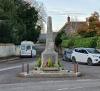 Front view of a stone obelisk on a small island at a road junction