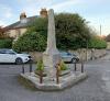 Side view of a stone obelisk on a small island at a road junction
