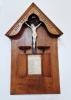 Wooden shrine with pitched top and figure of Christ at center