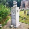 Stone pillar with figure or head of airman, wreath in relief