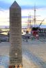 Obelisk memorial for HMS Royal Oak with HMS Warrior behind it.