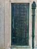 Five bronze plaques mounted on each side of large stone plinth