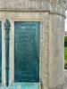 Five bronze plaques mounted on each side of large stone plinth