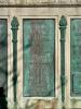 Five bronze plaques mounted on each side of large stone plinth