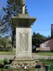 Plain cross atop square column with inscription