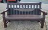 Wooden bench with submarine silhouette affixed; backing on to granite memorial