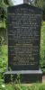 A marble gravestone with a shallow triangular top and eight names in addition to that remembered.