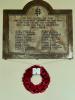 Nowy headed tablet above a wreath of poppies