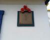 Brass plaque on side of Bus shelter. RBL logo with 3 3D poppies above