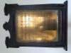 Wall-mounted brass plaque with dark wooden ornate frame. Black incised lettering (in Welsh). 