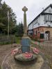 Stone cross on plinth with seats around base