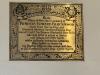 Ornate brass plaque with incised painted lettering.