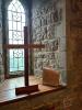Ceramic scroll situated next to wooden cross with window in background