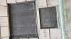 One of the wall mounted metal plaques with inscriptions in relief, on rusticated stone walls at bottom of tower.