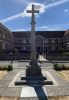Memorial cross set within a square memorial garden as viewed from the east