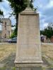 Large tapering plinth and cross with church in background