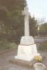 White stone cross on a plinth, with names written on its base.
