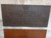Dark metal plaque with engraved crown and wording commemorating Admiral Luce