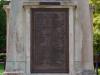 Cast bronze plaque with raised lettering.