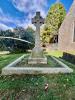 Celtic cross on pedestal set within kerb surround