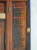 Names inscribed in black on triptych door panel