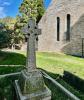 Celtic wheel cross with church building in background