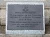 Metal plaque with raised lettering, mounted in a granite block.