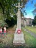 Cross on tapering column with church in background