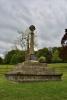 Three-stepped base surmounted by a square plinth and tapering octagonal column. All topped with Celtic cross and moulded collar below. Metal plaque attached to front of plinth is inscribed in white lettering. 