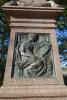 Close up of bronze panel depicting "fame"