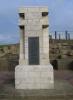 Stone pillar with metal plaque containing memorial inscription.