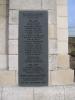 Inscription and names plaque on a stone pillar which is only partly visible as the image focuses on the inscription