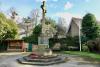 The cross from the West, with the shelter to the left, and the flagpole and other memorials to the right