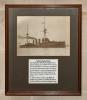 Glazed frame, containing a monochrome photo of HMS Black Prince, and handwritten card.