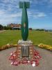 Second World War Bomb carcasse atop brick plinth