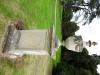 Side angle shot of memorial featuring face with latin dedication