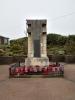 Stone pillar with metal plaque containing memorial inscription.