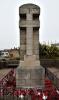 Memorial stone pillar enclosed in a low wrought iron railing.