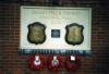 Three plaques on a white background on a brick wall