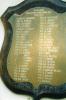 Plaque in shield-like format on a wooden background